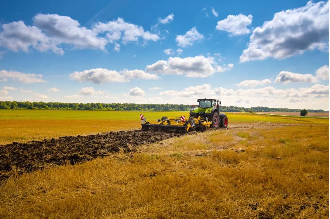 tractor with a heavy disc harrow in the field